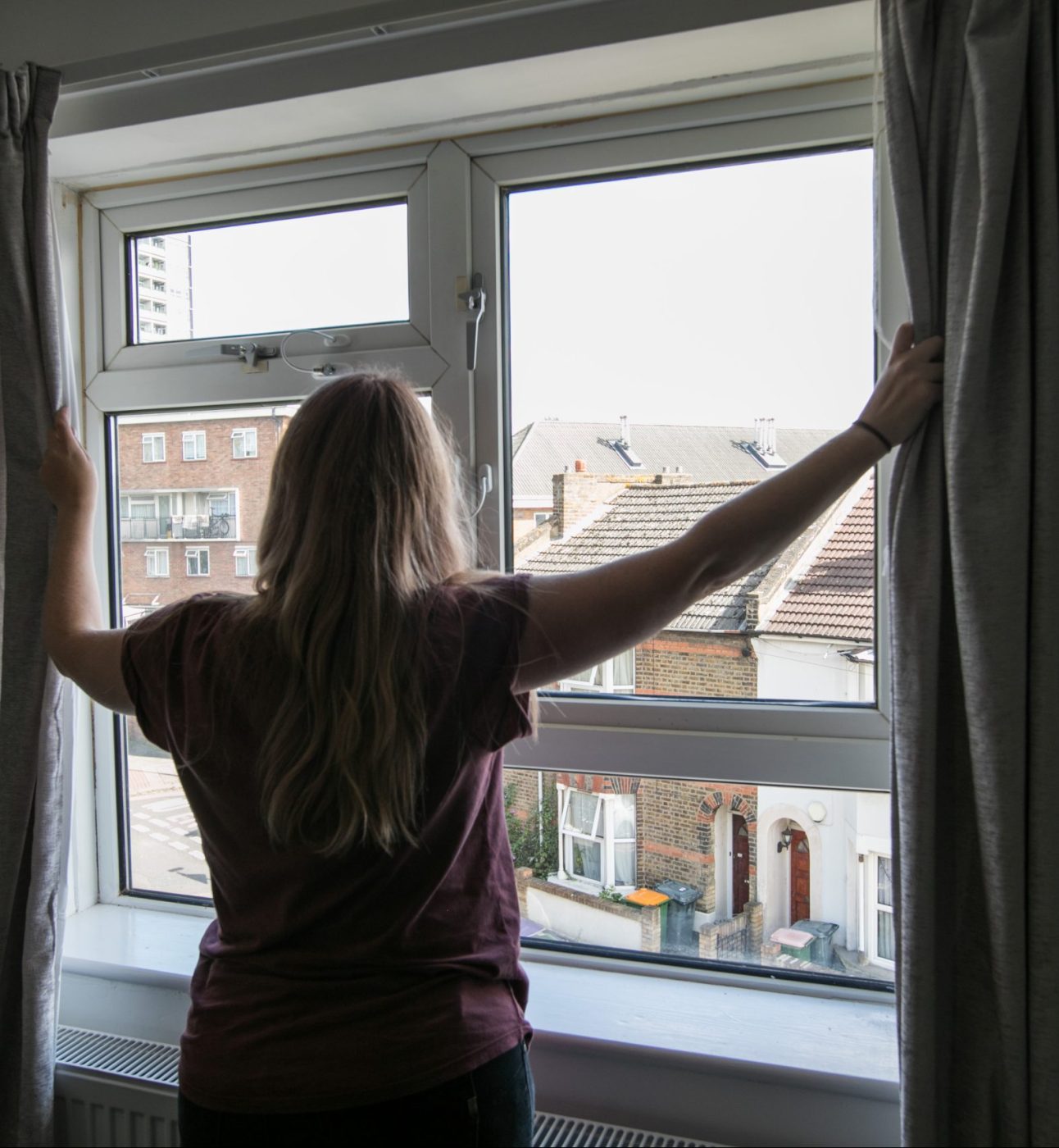 image of housing service user opening curtains