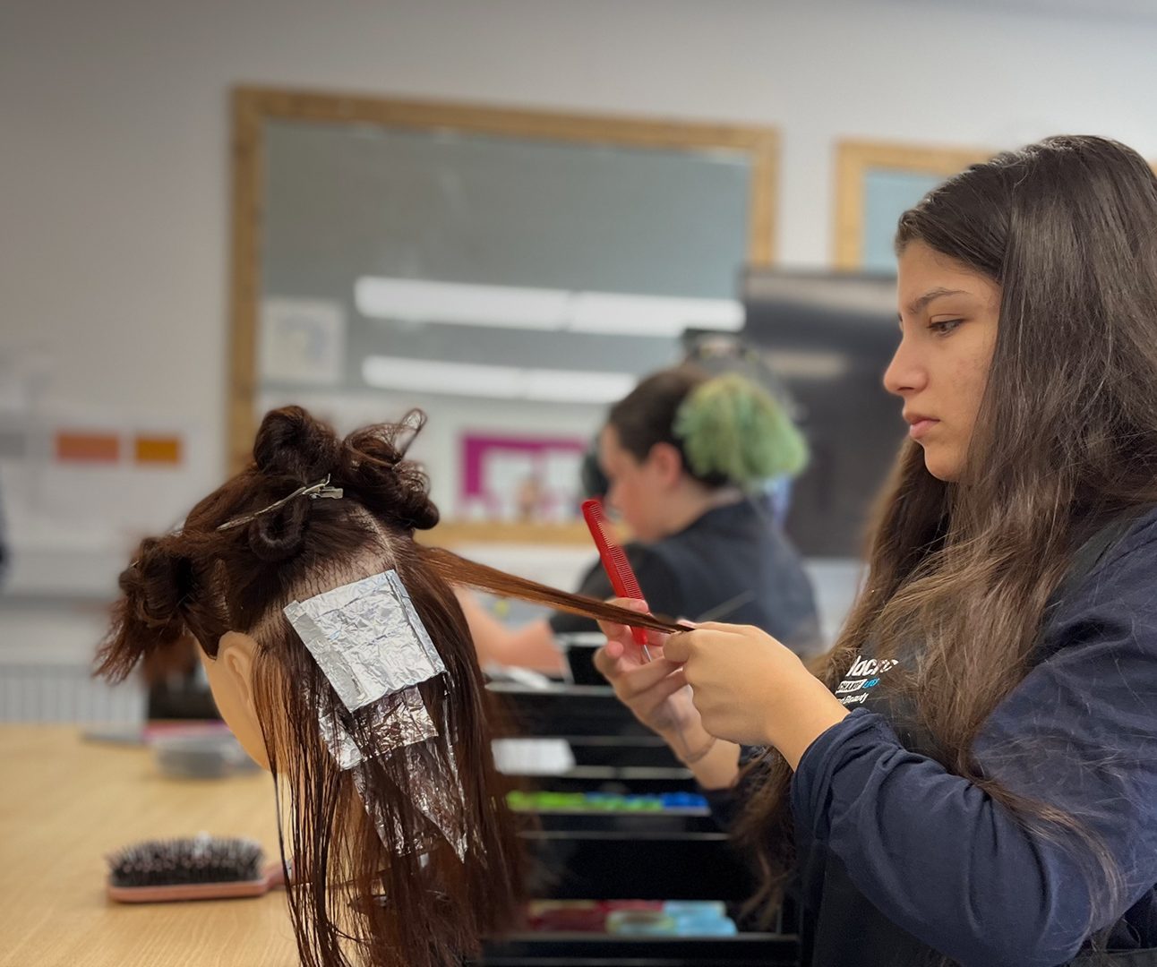 image of a learner practicing hairdressing for her course.