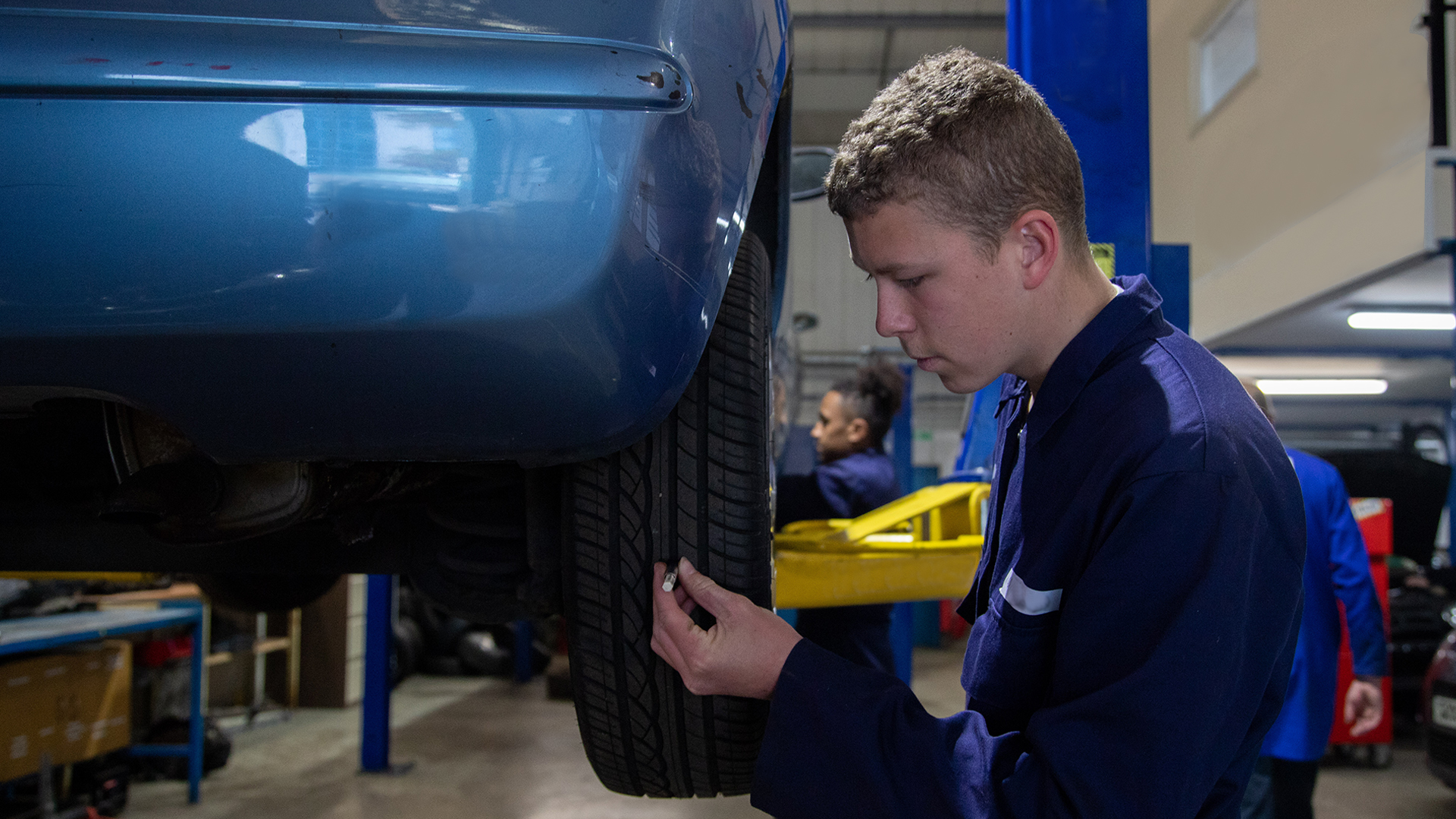 Motor vehicle student working on a car