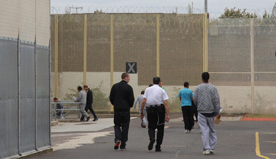 People walking inside of prison gates